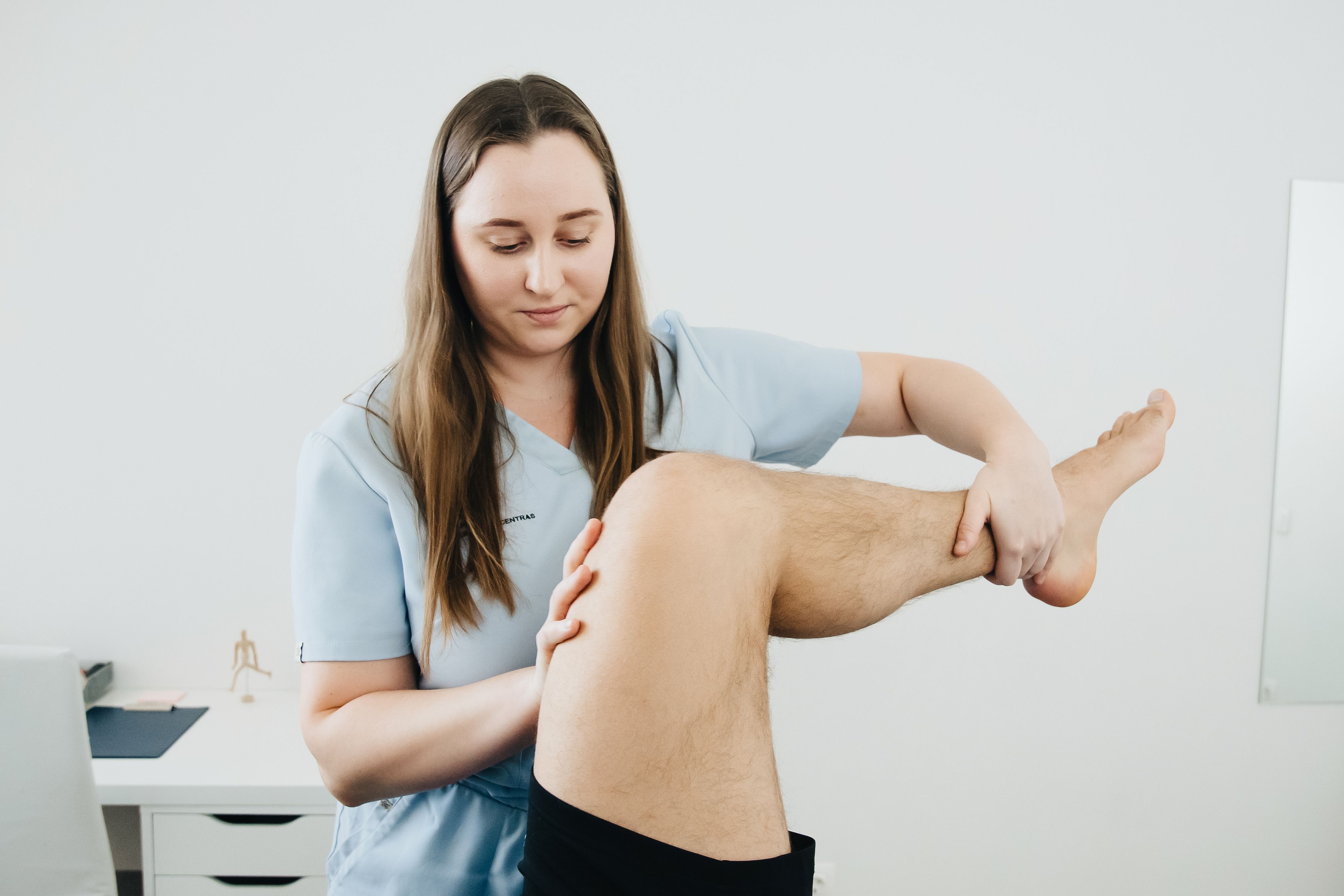 A-physiotherapist-assisting-a-patients-leg-therapy-session-indoors-focusing-on-rehabilitation